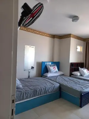 a bedroom with two beds and a ceiling fan at شقة فندقية على البحر مباشرا 2 in Hurghada