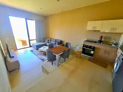 a kitchen and living room with a table and a couch at Elgouna, Tawila island in Hurghada
