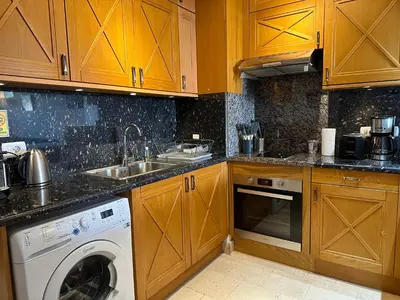 a kitchen with wooden cabinets and a washing machine at Sunshine Y1-1-7 in Hurghada