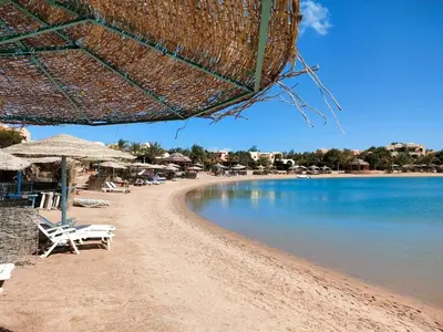 a beach with chairs and an umbrella and the water at Sunshine Y1-1-7 in Hurghada