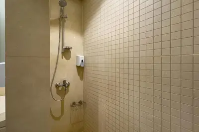 a shower stall in a bathroom with white tiles at Remarkable & Rare 2BDR Mangroovy Free Pool & Beach in Hurghada
