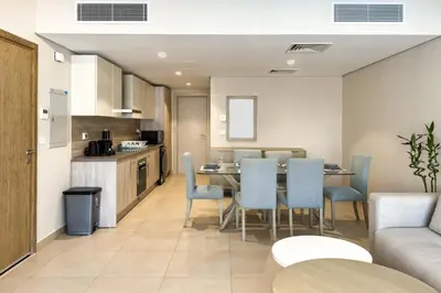 a kitchen and a dining room with a table and chairs at Remarkable & Rare 2BDR Mangroovy Free Pool & Beach in Hurghada
