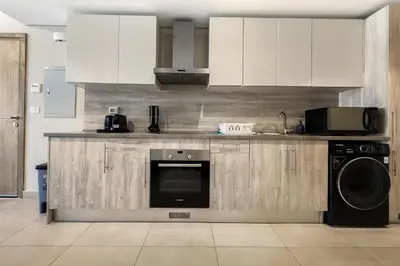 a kitchen with white cabinets and a dishwasher at Remarkable & Rare 2BDR Mangroovy Free Pool & Beach in Hurghada