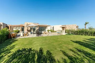 a yard with a large lawn in front of a house at Modern luxury villa in SomaBay in Hurghada