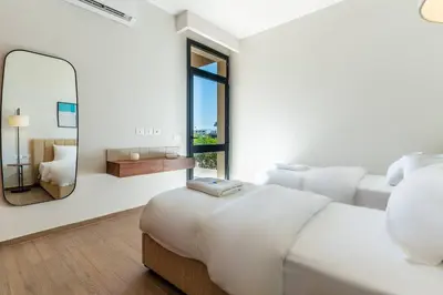 a white bedroom with a large bed and a mirror at Modern luxury villa in SomaBay in Hurghada
