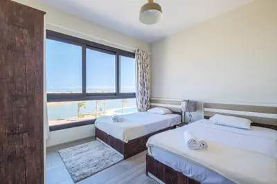 two beds in a room with a view of the ocean at Gouna Getaway in Hurghada