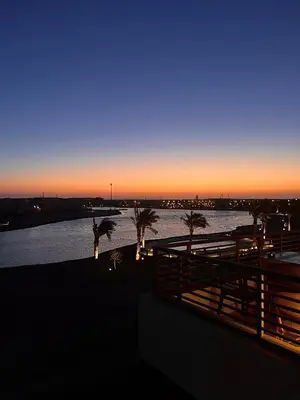 a sunset over a body of water with palm trees at Gouna Getaway in Hurghada