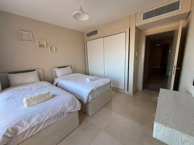 a bedroom with two beds and a sliding glass door at El gouna mangrouovy in Hurghada