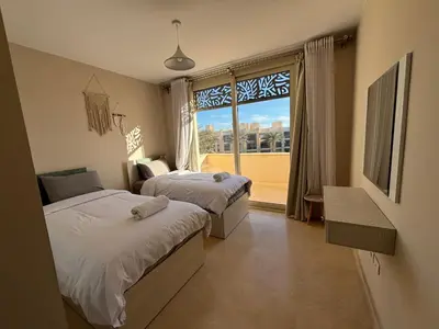 a bedroom with two beds and a large window at El gouna mangrouovy in Hurghada