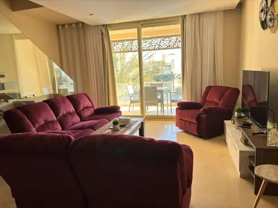 a living room with two red couches and a television at El gouna mangrouovy in Hurghada