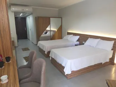 a hotel room with two beds and a chair at Scandic resort hurghada in Hurghada