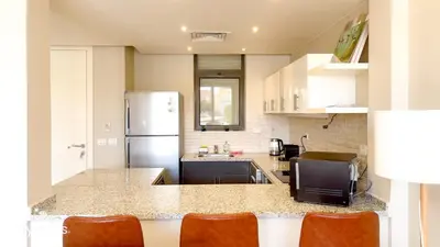 a kitchen with a refrigerator and a counter top at Ollystays Tawila 3BR Townhouse Shared Pool in Hurghada