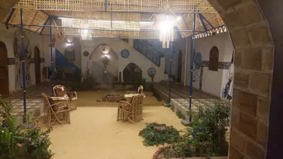 a room with chairs and a table in a building at Nuba life hostel in Najâ€˜ al MadÄbb