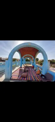 a view of a patio with benches and an archway at Nuba life hostel in Najâ€˜ al MadÄbb