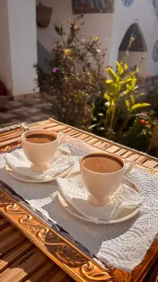 two cups of coffee sitting on a wooden table at Nuba life hostel in Najâ€˜ al MadÄbb