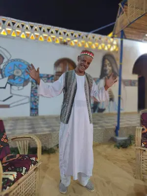 a man is standing in front of a painting at Nuba life hostel in Najâ€˜ al MadÄbb