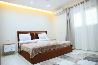 a bedroom with a bed and a large window at Peaceful Magawish Apartment in Hurghada