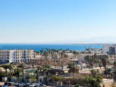 a city with palm trees and buildings and the ocean at Aldau Heights in Hurghada