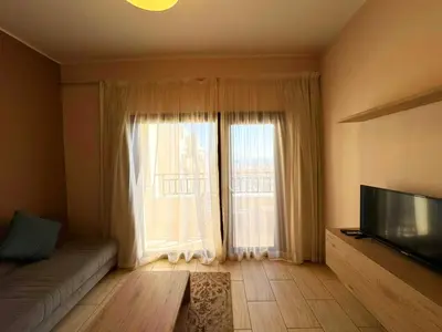 a living room with a couch and a large window at Aldau Heights in Hurghada