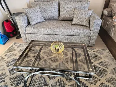 a living room with a couch and a glass table at Taiba Golden Central Hurghada in Hurghada
