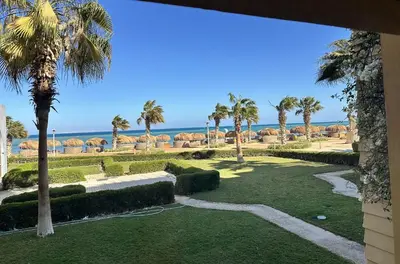a view of a park with palm trees and the ocean at Marina Beach Front 3 Br Duplex in Hurghada