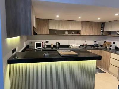 a kitchen with a black counter top and wooden cabinets at Marina Beach Front 3 Br Duplex in Hurghada