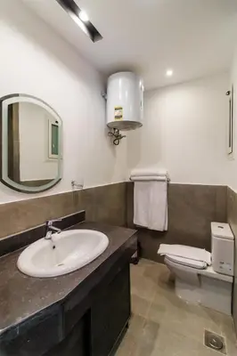 a bathroom with a sink and a toilet and a mirror at Al Saraya Sahl Hasheesh by Peak -One-Bedroom Apartment C316 in Hurghada