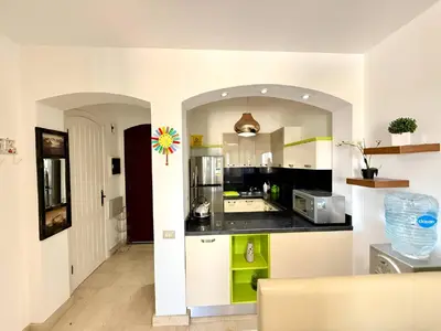 a kitchen with a black counter top in a room at Exquisite 1BR Chalet with Pool and Beach Front El Gouna in Hurghada