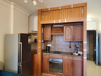 a kitchen with wooden cabinets and a stainless steel refrigerator at Studio for rent in Hurghada 116 in Hurghada