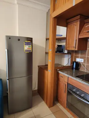 a kitchen with a stainless steel refrigerator and wooden cabinets at Studio for rent in Hurghada 116 in Hurghada