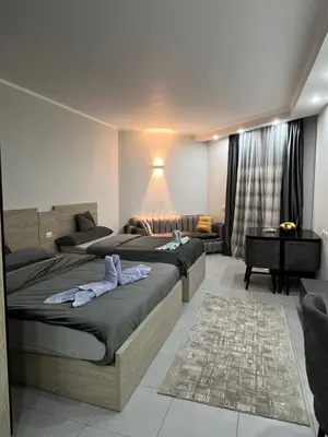 a bedroom with two beds and a couch at Scandic Resort Hurghada in Hurghada