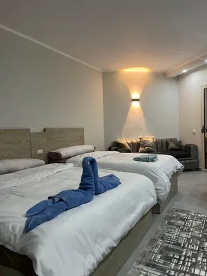 a room with three beds and a couch at Scandic Resort Hurghada in Hurghada