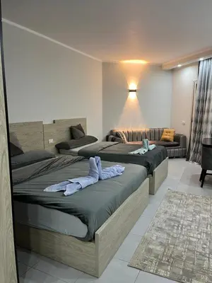 a bedroom with two beds and a couch at Scandic Resort Hurghada in Hurghada
