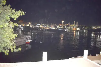 a body of water with a city at night at Nile Moon in Jazīrat Aswān