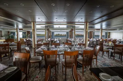 a restaurant on a cruise ship with tables and chairs at Renaissance Nile Cruise - Every Saturday from Luxor To Aswan for 4 Nights , and every Wednesday from Aswan To Luxor for 3 Nights in Luxor