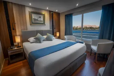 a bedroom with a large bed and a large window at Renaissance Nile Cruise - Every Saturday from Luxor To Aswan for 4 Nights , and every Wednesday from Aswan To Luxor for 3 Nights in Luxor