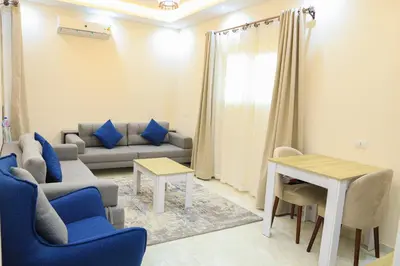 a living room with a couch and a table at Peaceful Magawish Apartment in Hurghada