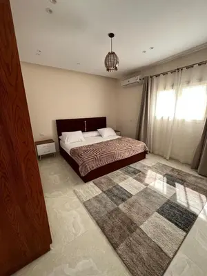 a bedroom with a large bed and a rug at Peaceful Magawish Apartment in Hurghada