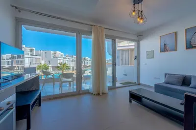 a living room with a blue couch and a large window at Modern 1BR with Pool View in Sholan El Gouna in Hurghada