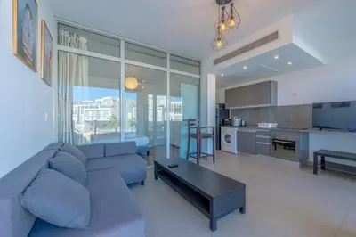 a living room with a blue couch and a kitchen at Modern 1BR with Pool View in Sholan El Gouna in Hurghada