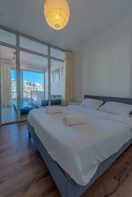 a large white bed in a bedroom with a large window at Modern 1BR with Pool View in Sholan El Gouna in Hurghada