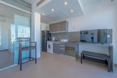 a kitchen with a counter and a table in it at Modern 1BR with Pool View in Sholan El Gouna in Hurghada