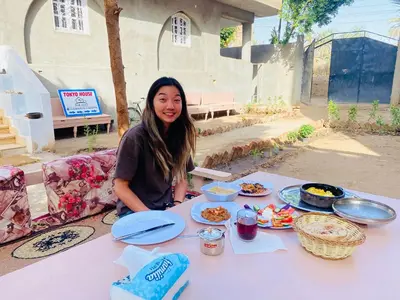 a woman sitting at a table with plates of food at Tokyo House Luxor in Luxor