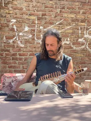 a man sitting on the ground playing a guitar at Tokyo House Luxor in Luxor