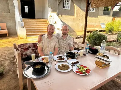 two men sitting at a table with food on it at Tokyo House Luxor in Luxor