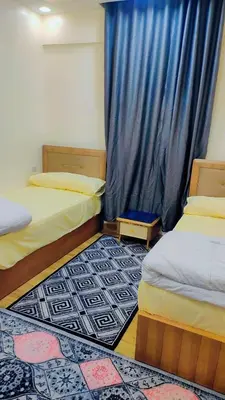 a room with two beds and a blue curtain at Carrefour Hurghada city centre in Hurghada