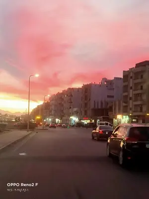 a city street with cars parked on the road at happy vacation in Hurghada