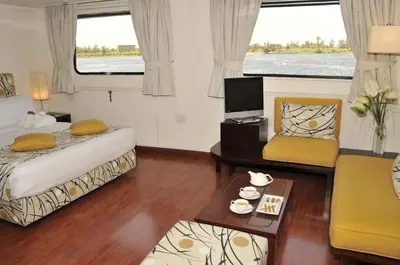 a bedroom with a bed and a couch and a table at King of The Vally Nile Cruise Aswan To Luxor 3 Night And visit the Nubian village in Aswan