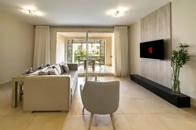 a living room with a couch and a table at Modish & Modern 1BDR Poolfront Mangroovy Free Pool & Beach in Hurghada