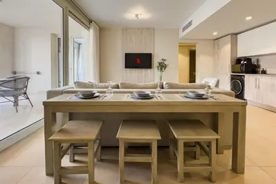 a kitchen and living room with a table and chairs at Modish & Modern 1BDR Poolfront Mangroovy Free Pool & Beach in Hurghada